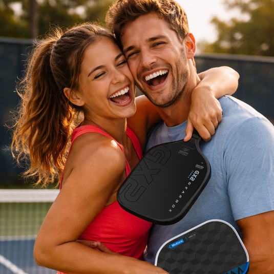 Smiling couple holding pickleball paddles and embracing on the courts at The Fort in Fort Lauderdale.