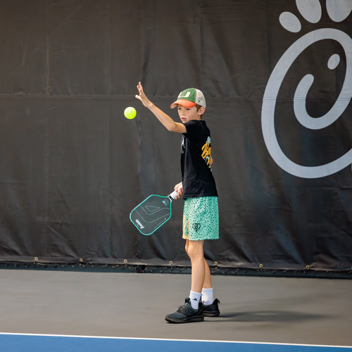 Young pickleball player practicing a serve on an indoor court at The Fort in Fort Lauderdale.
