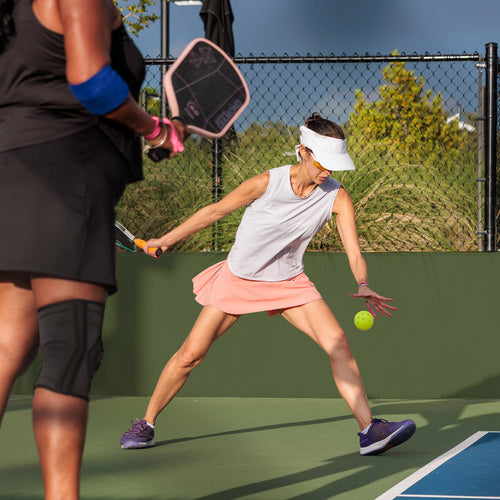 Two players in a pickleball match on an outdoor court at The Fort