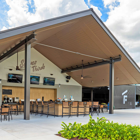 Serves & Thirds bar area at The Fort with covered outdoor seating and bar stools