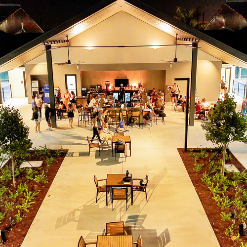 Nighttime view of Serves and Thirds patio with outdoor seating and bar at The Fort