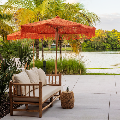 Outdoor lounge seating with red umbrellas and lake view at The Fort